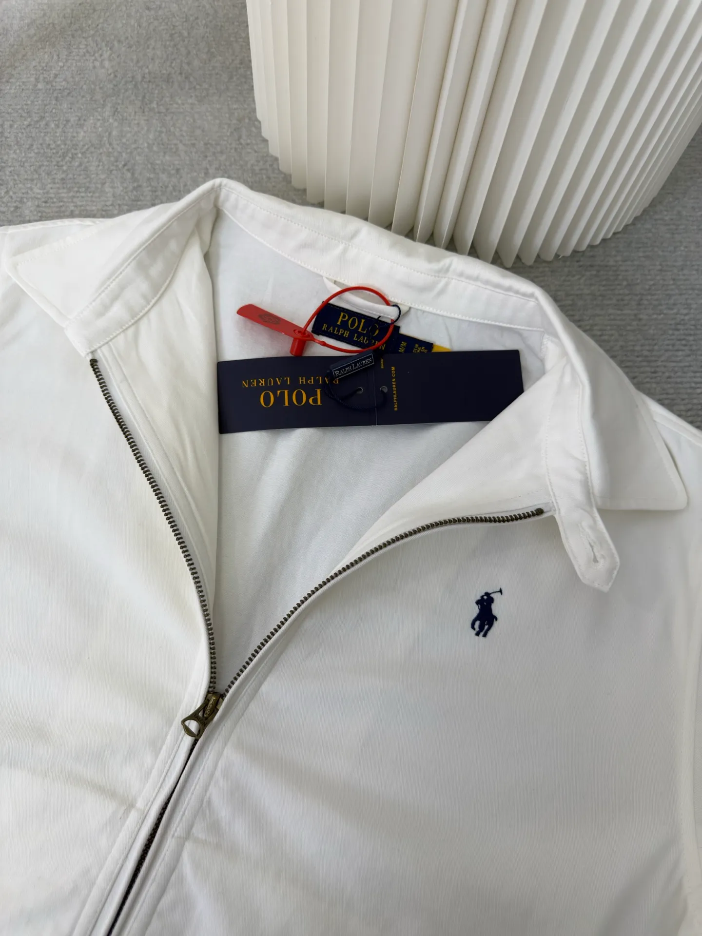 P490 Ralph Lauren embroidered zipper jacket. Customized cloud-velvet white twill cotton. Soft and silky. Comfortable against the skin. Dressed in pure white. Exuding innate elegance. Exquisite indigo pony logo embellished with it. Fully recognizable. Bringing a breath of freedom and vitality. Pure and smart color symphony. Reconstructing classics with neat silhouettes. Defining modern relaxation with versatile genes. Using imported machine embroidery technology. Using advanced computer control systems and precision mechanical components. Realize the iconic pony embroidery operation with high precision and smooth and delicate lines. Template machine bag opening. Preset templates guide the position, shape and size of the bag opening. Accuracy ensures the quality of the bag opening effect. The hem is made in one go using a three-needle waist-drawing machine. The elastic band and fabric are sewn together in the same process using the machine's special needle position and feeding mechanism. The three-needle design is stronger and can evenly distribute pressure to ensure that the elastic band and the fabric are tightly fitted. The fabrics have been washed. Better feel and texture, not easy to deform, not easy to shrink, not easy to fade, maintain long-term beauty, size: S M L XL